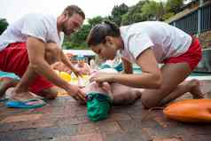救援工人帮助无意识的高级男人。在游泳池边
