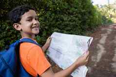 微笑男孩阅读地图走路径
