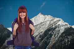 红头发女人微笑照片前面白雪覆盖的山背景