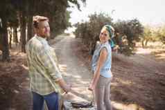 微笑年轻的夫妇携带篮子场橄榄农场