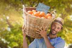 复合图像微笑年轻的男人。携带橙色水果柳条篮子