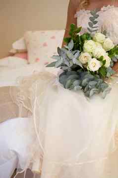 上腹部新娘婚礼衣服持有花束床上