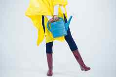 女人黄色的雨衣持有浇水