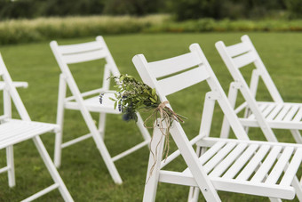 白色婚礼椅子装饰新鲜的花绿色草空木椅子客人绿色草坪上花园准备婚礼仪式