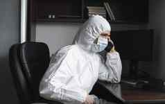 男人。医疗面具橡胶手套坐在首页说话电话朋友业务合作伙伴检疫男人。远程工作流感大流行科维德冠状病毒