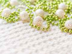 圣诞节一年装饰白色针织背景金属光灯泡精致的模式绿色珠子