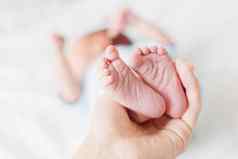 妈妈。持有新生儿婴儿的只高跟鞋小脚女人的手舒适的早....首页
