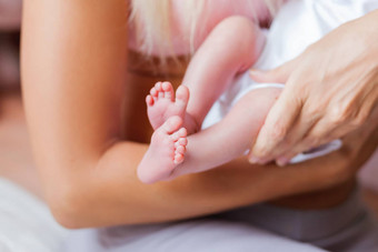 妈妈。持有新生儿婴儿的只高跟鞋小脚女人的手舒适的早....首页