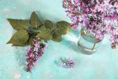花束淡紫色花朵玻璃瓶光背景花春天纹理