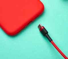 红色的智能手机电缆纺织编织绿色背景