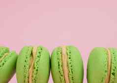 绿色轮烤蛋白杏仁饼干马卡龙粉红色的背景美食