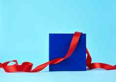 广场蓝色的纸板盒子礼物扭曲的丝绸红色的丝带