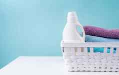 洗衣篮子洗涤剂瓶桩清洁毛巾白色表格孤立的蓝色的背景