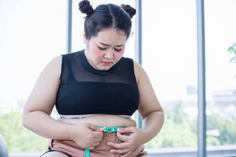 亚洲超重女人测量脂肪层<strong>腰围</strong>他