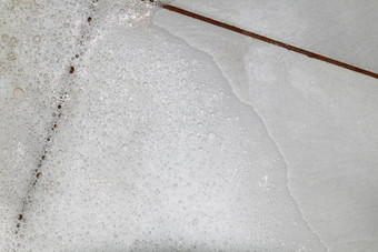 泡沫肥皂洗涤剂擦洗浴室地板上污垢湿泡沫白色泡沫<strong>洗发</strong>水洗平铺的地板上前视图