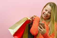 女孩手持有现代移动电话在线购物白色屏幕屏幕在线购物概念智能手机女孩粉红色的背景