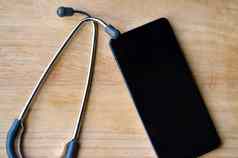 听诊器移动电话显示空白色屏幕木背景广告医疗保健互联网应用程序健康科技软件概念