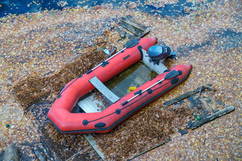 红色的船浮动湖大坝征服了死棕色（的）叶概念自然定位焊男人。使结构冠状病毒流感大流行锁