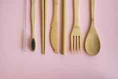 生态友好的竹子餐具集情况下粉红色的背景浪费概念集竹子餐具情况下铺设表格勺子叉刀牙刷管中国人棒