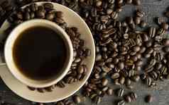 咖啡杯烤咖啡豆子木表格背景杯子黑色的咖啡分散咖啡豆子木表格新鲜的咖啡豆子