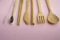 生态友好的竹子餐具集情况下粉红色的背景浪费概念集竹子餐具情况下铺设表格勺子叉刀牙刷管中国人棒