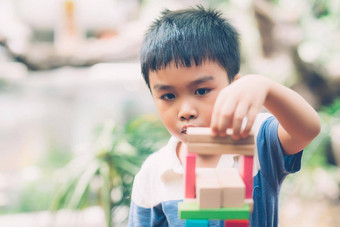 亚洲年轻的男孩玩木块玩具<strong>表格</strong>有<strong>创意</strong>的发展享受快乐孩子学习技能活动谜题创造力游戏桌子上首页教育概念