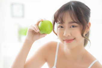 美丽的肖像年轻的亚洲女人持有吃绿色苹果水果卧室首页生活方式营养女孩健康的护理重量损失健康健康概念