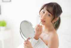 美丽的肖像年轻的亚洲女人镜子应用化妆口红房间美嘴唇亚洲女孩化妆化妆品时尚口首页生活方式健康护理概念