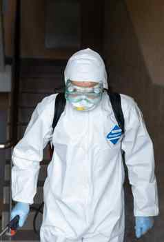 乌克兰基辅男人。白色保护西装面具消毒室内表面内部建筑冠状病毒疫情感染预防控制疫情