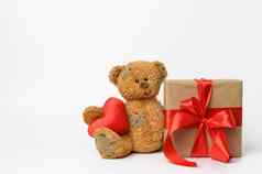 可爱的泰迪熊持有红色的心盒子礼物系红色的丝绸丝带