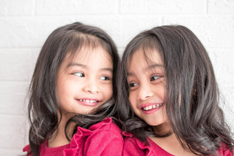 相同的<strong>双</strong>胞胎女孩姐妹摆姿势相机快乐<strong>双</strong>胞胎姐妹礼服相机微笑额视图白色背景