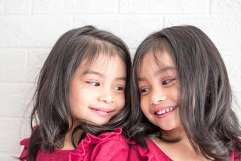 相同的<strong>双</strong>胞胎女孩姐妹摆姿势相机快乐<strong>双</strong>胞胎姐妹礼服相机微笑额视图白色背景