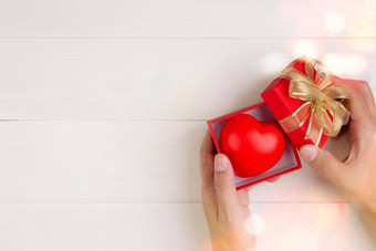 情人节一天手<strong>开放</strong>红色的礼物盒子心形状木白色背景庆祝<strong>活动</strong>周年纪念日给爱礼物浪漫的惊喜假期节日概念