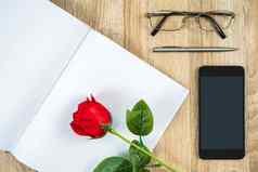红色的玫瑰空白笔记本日记智能手机情人节概念