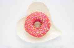 粉红色的甜蜜的甜甜圈谎言白色心形的板白色背景
