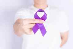世界癌症一天手持有紫色的丝带灰色背景医疗保健医疗概念