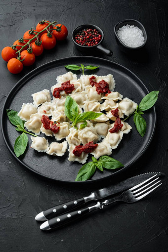 意式馄饨意大利面蘑菇奶油酱汁奶酪意大利食物风格罗勒帕尔玛西红柿黑色的板黑色的背景