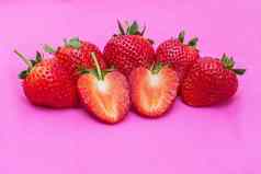 草莓甜蜜的红色的水果seed-studded表面特写镜头集团红色的浆果心形的水果粉红色的织物纹理