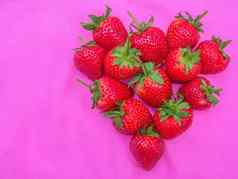 红色的心集团草莓甜蜜的水果seed-studded特写镜头纹理红色的浆果心形的水果粉红色的织物