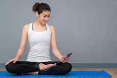 年轻的亚洲女人享受音乐练习瑜伽瑜伽健康的体育运动健身房瑜伽冥想好好处健康照片概念瑜伽体育运动健康的生活方式