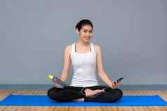 年轻的亚洲女人享受音乐练习瑜伽瑜伽健康的体育运动健身房瑜伽冥想好好处健康照片概念瑜伽体育运动健康的生活方式