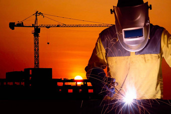 焊接工人焊接钢结构建设起重机建筑建设网站日落建设工业工作概念