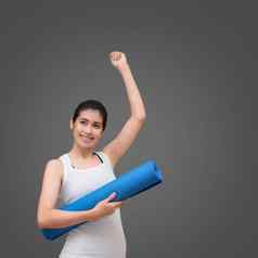 年轻的亚洲女人快乐微笑持有瑜伽席瑜伽健康的体育运动健身房瑜伽冥想好好处健康照片概念瑜伽体育运动健康的生活方式