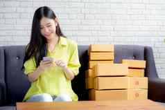 年轻的亚洲女人企业家检查订单智能手机客户购买在线物流交付在线购物女卖方业务锻造商人电话