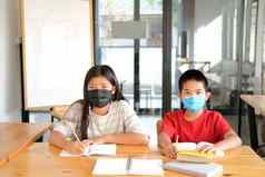 女孩男孩学生穿脸面具研究写作笔记家庭作业学习教育学校