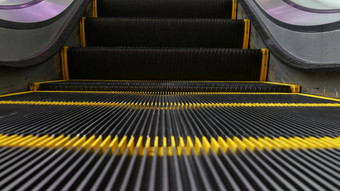 低角毛圈的角度来看视图现代<strong>自动</strong>扶梯楼梯<strong>自动</strong>化<strong>电梯</strong>机制黄色的行楼梯照亮紫色的光未来主义的空机械楼梯移动直