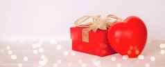 红色的礼物盒子心形状木表格散景背景爱浪漫礼物庆祝活动周年纪念日惊喜桌子上快乐生日情人节一天概念