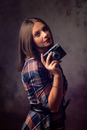 女孩摄影师复古的相机工作室摄影灰色的背景
