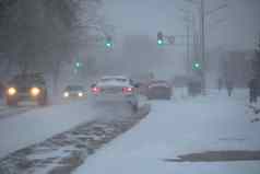 白雪覆盖的路汽车风暴暴雪降雪冬天坏天气城市极端的冬天天气条件北汽车开车白雪覆盖的街道城市