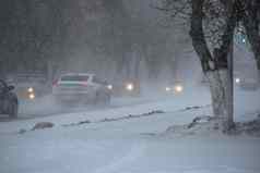 白雪覆盖的路汽车风暴暴雪降雪冬天坏天气城市极端的冬天天气条件北汽车开车白雪覆盖的街道城市